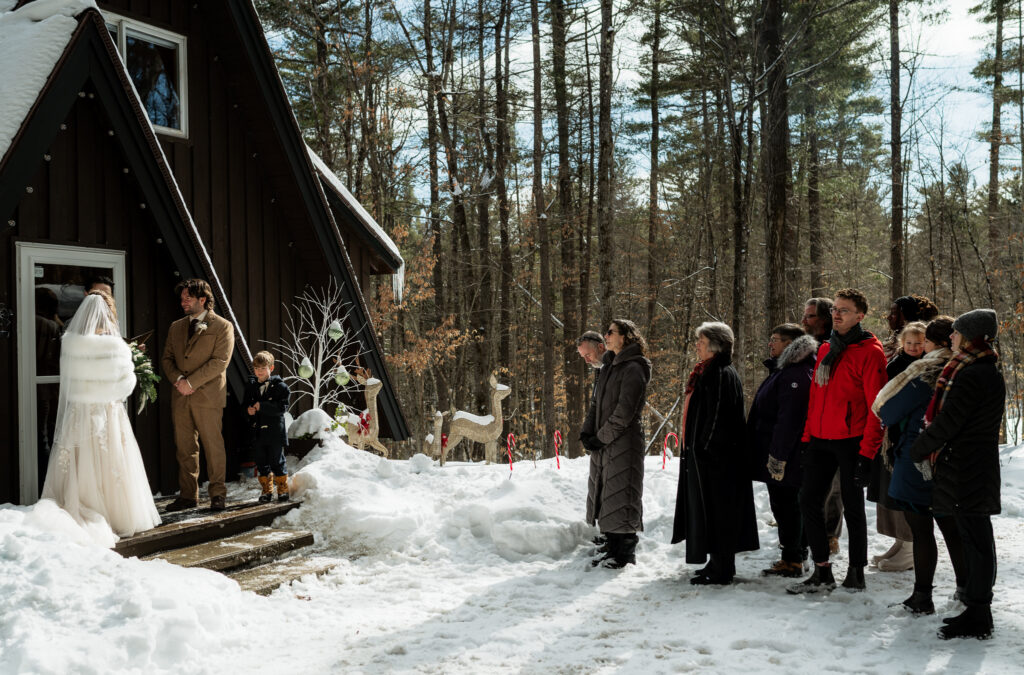 A couple gets married at an air bnb in winter time with their immediate family standing by watching them. 