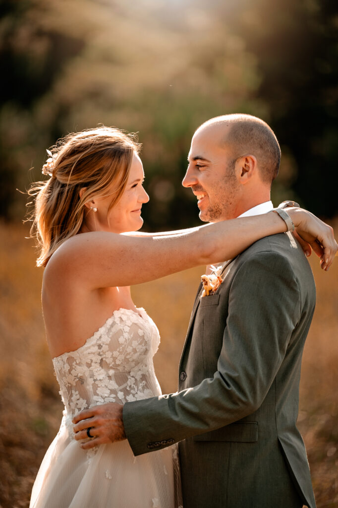 bride and groom look at eachother in the golden morning light