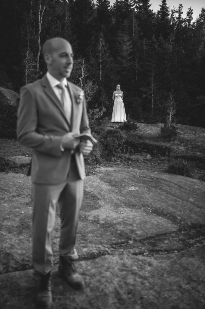 Bride looks at groom who is turned around for first look.