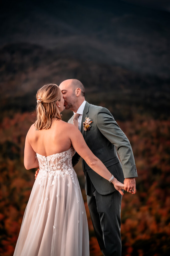 Bride and groom kiss at sunrise.