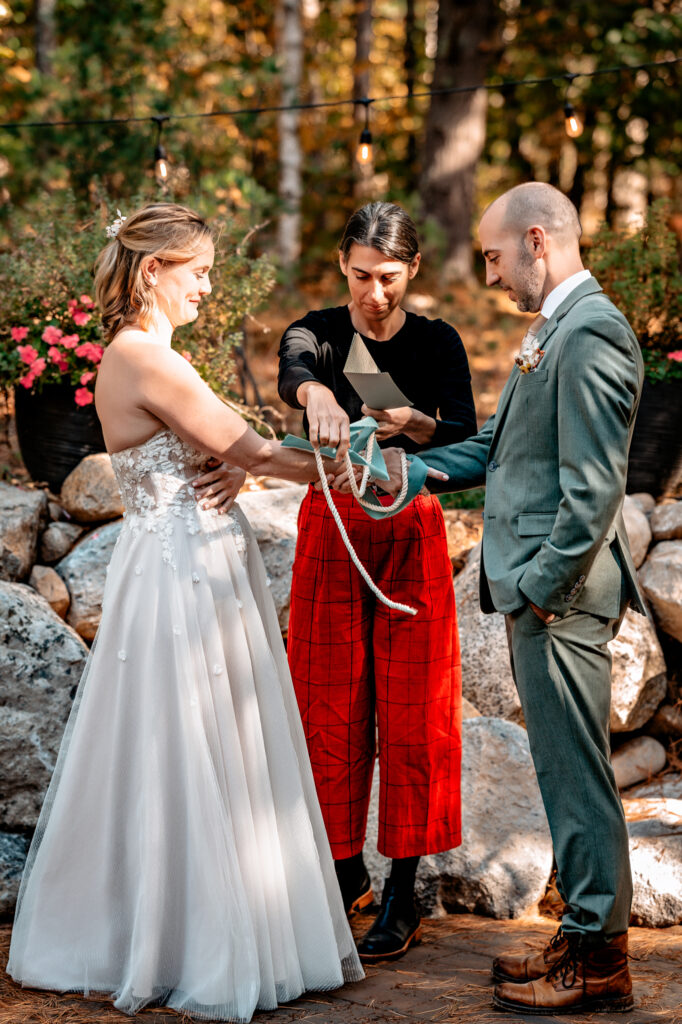 knot tying ceremony with bride and groom and officiant