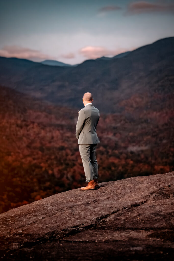 Groom looks out at the mountains in the fall.