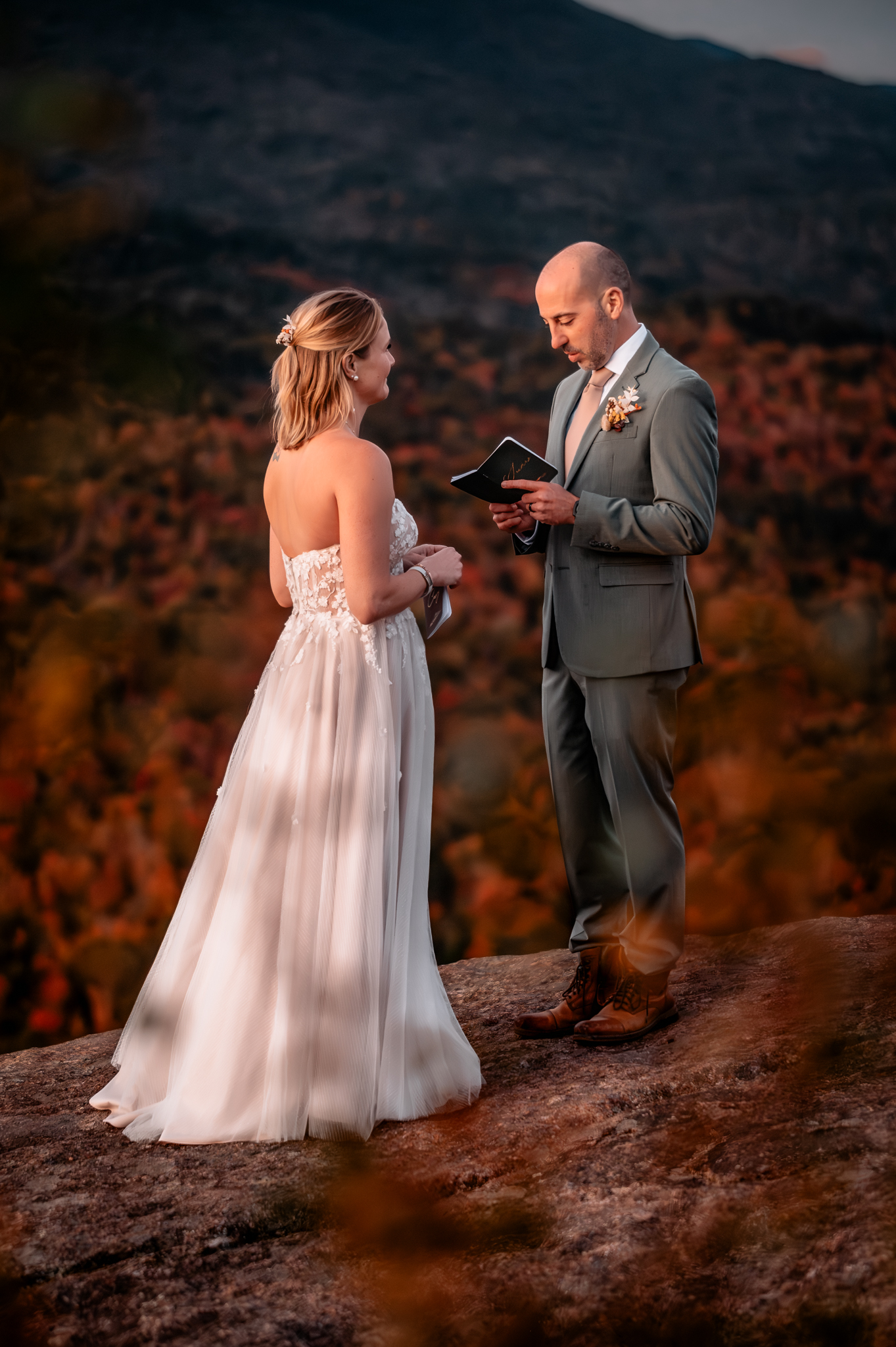 Bride and groom exchanging vows on a mountaintop during fall elopement at sunrise.