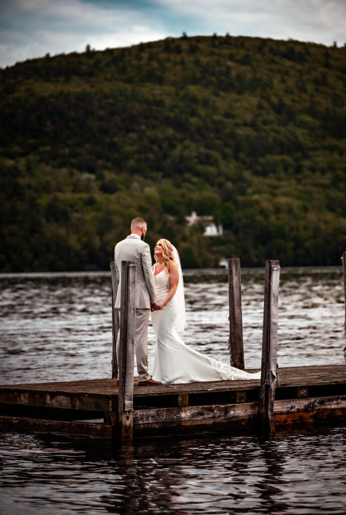A summer elopement with a couple exchanging vows on a dock in lake george.