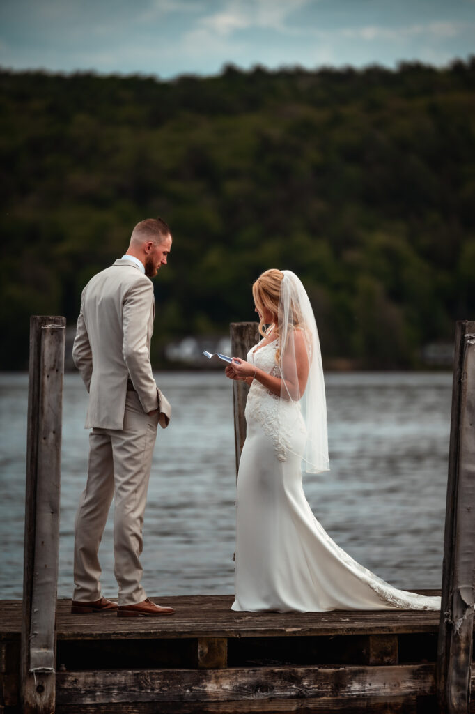 A summer elopement with a couple exchanging vows on a dock in lake george.