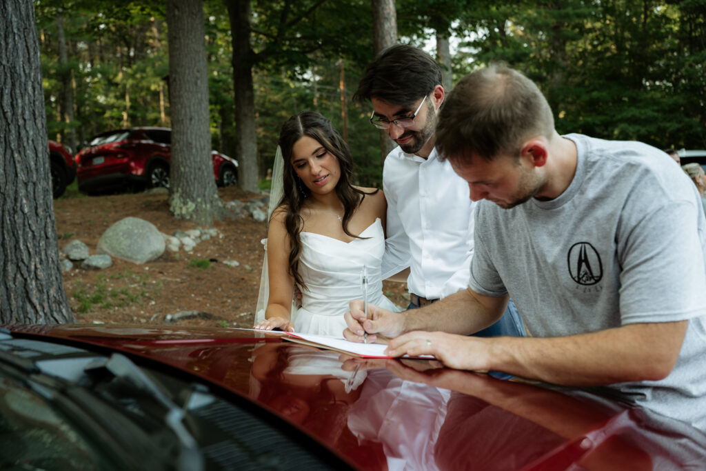 A couple and their officiant sign marriage license. 