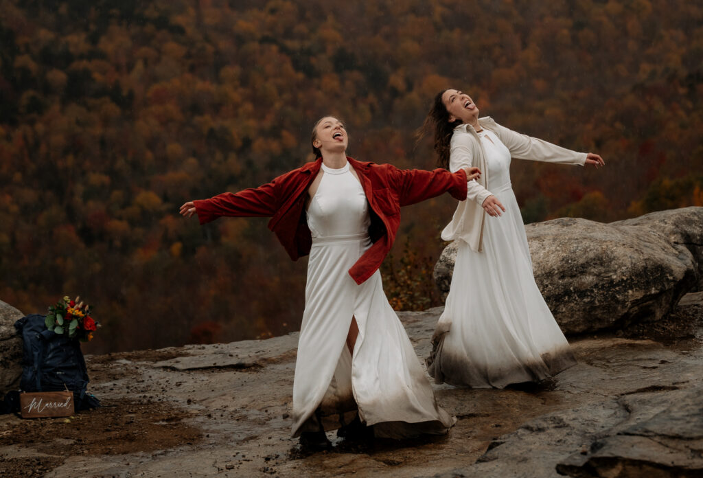 Two Brides dance in the rain on top of a mountain in the fall. 