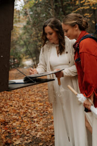 Two brides sign trail register in the Adirondacks.