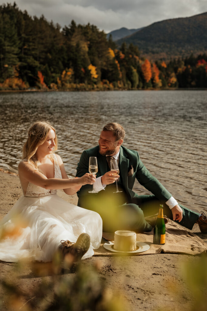 A couple toasts with champagne at Heart Lake Elopement adirondacks.