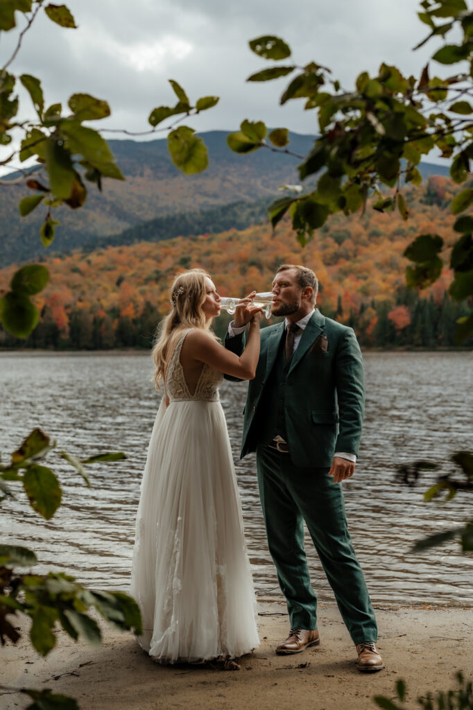 A couple toasts with champagne at Heart Lake Elopement adirondacks.