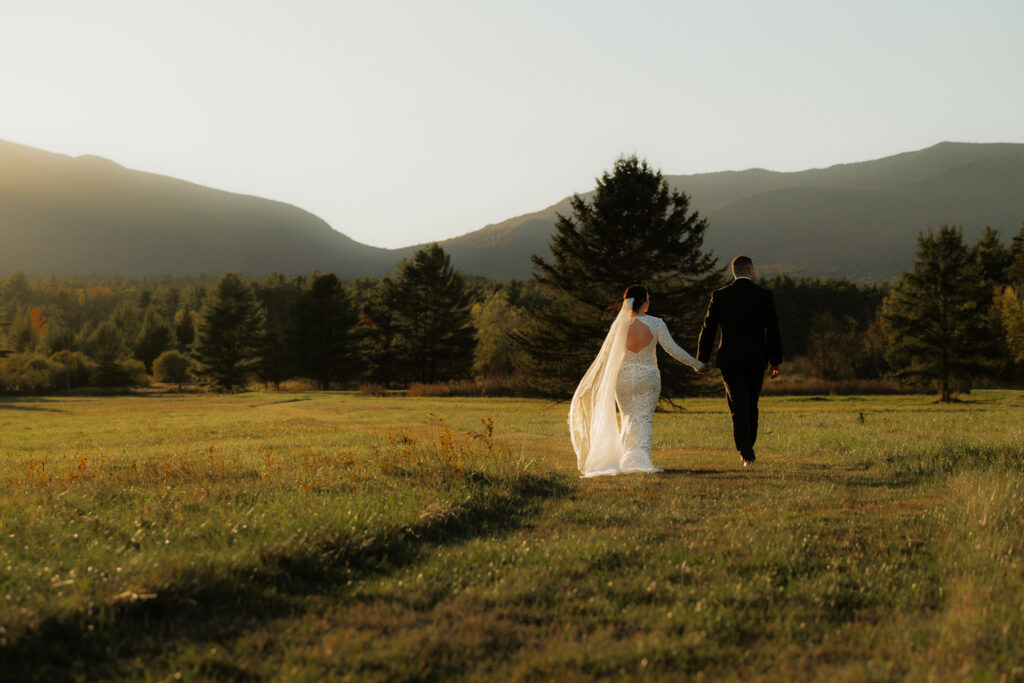 Couple walks into the sunset in the mountains together in wedding attire