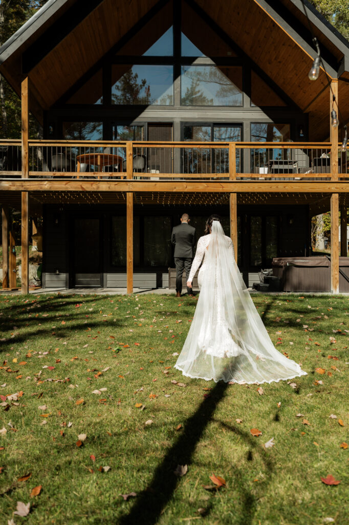 bride walking up to groom for an air bnb first look in the sun.