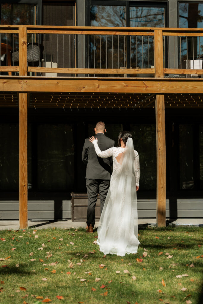 Bride taps groom on the shoulder for first look.