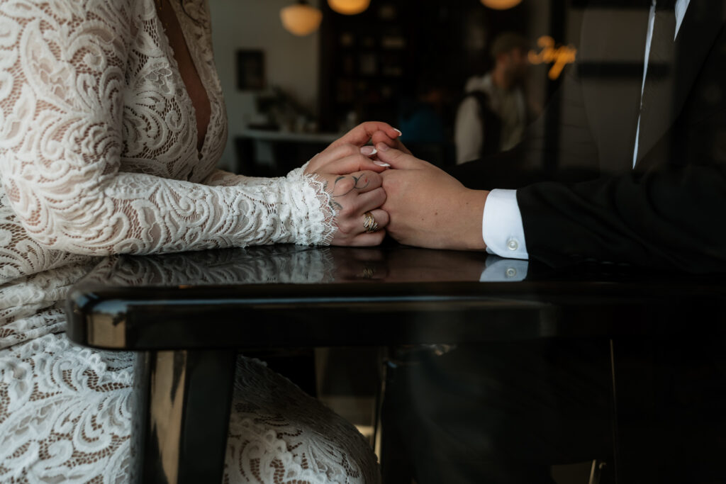 Couple holds hands at table.