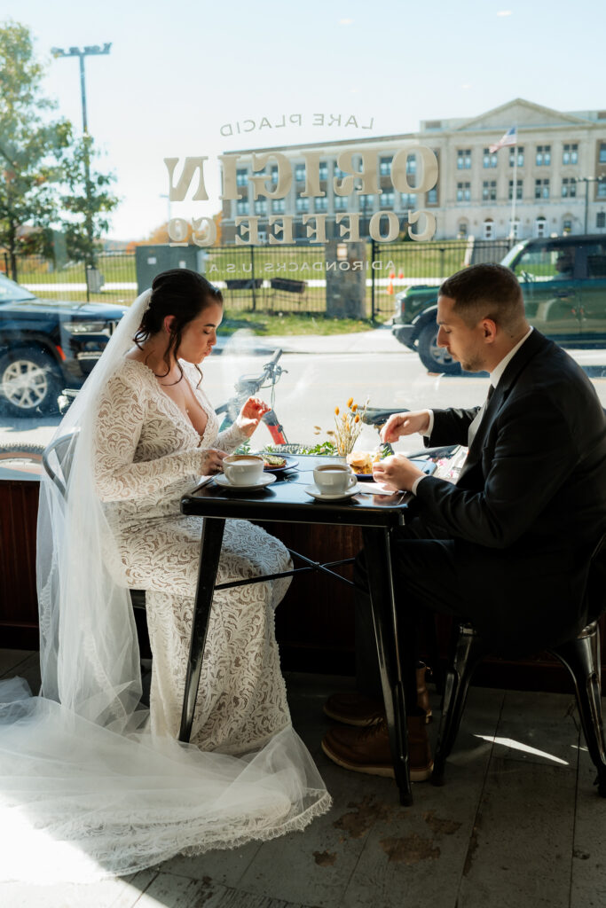 Couple spends elopement morning in the Adirondacks at a coffee shop having breakfast.