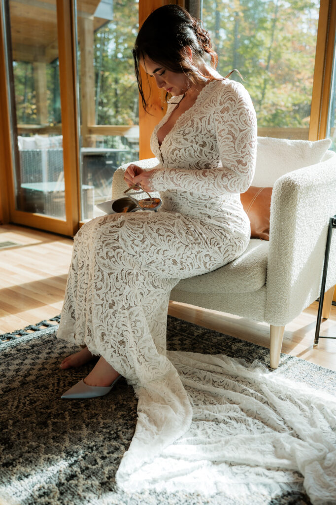 Bride unbuckling her wedding heels while on a couch in an air bnb.