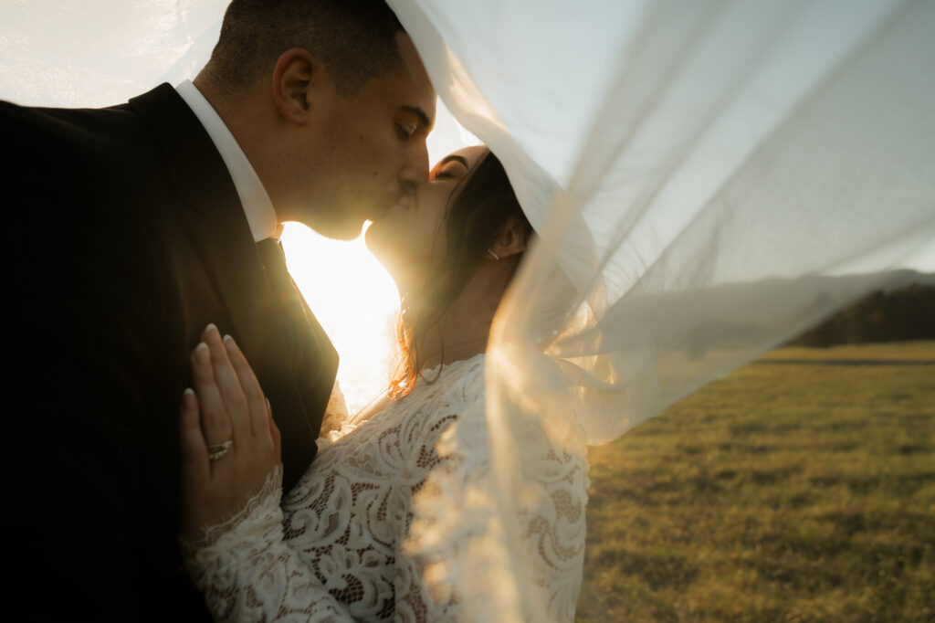 veil photo of couple kissing at sunset