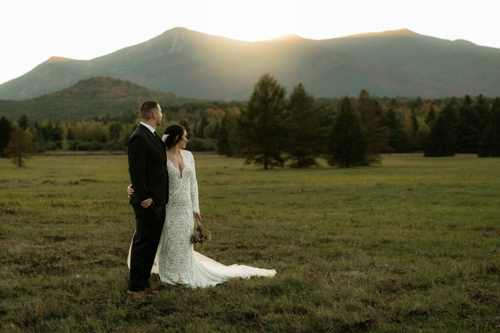 A couple watches the final light leave the valley in the adirondacks as the sun sets over the mountains.