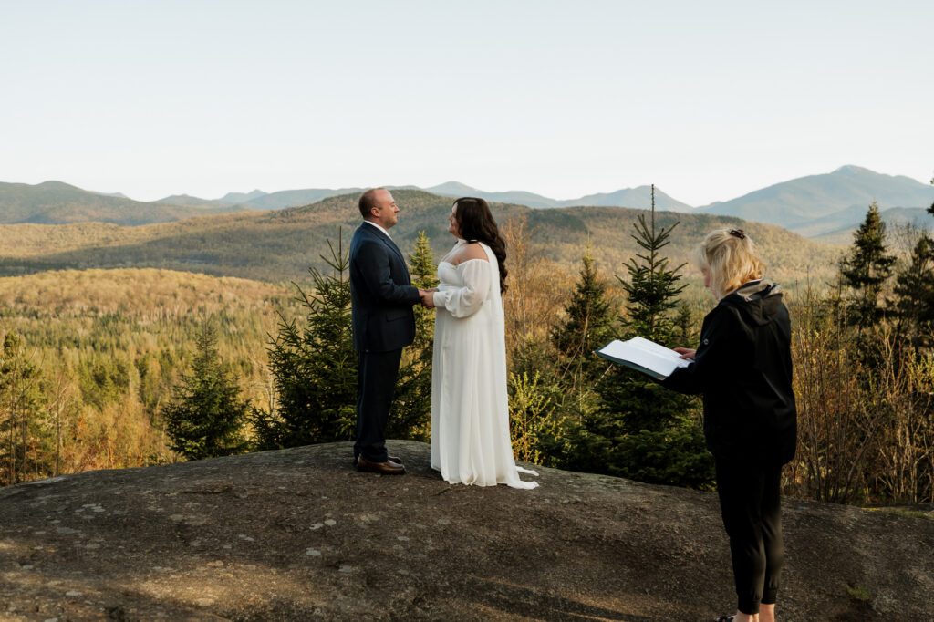 A couple elopes at scotts cobble weddings on the summit with spring mountains behind them.