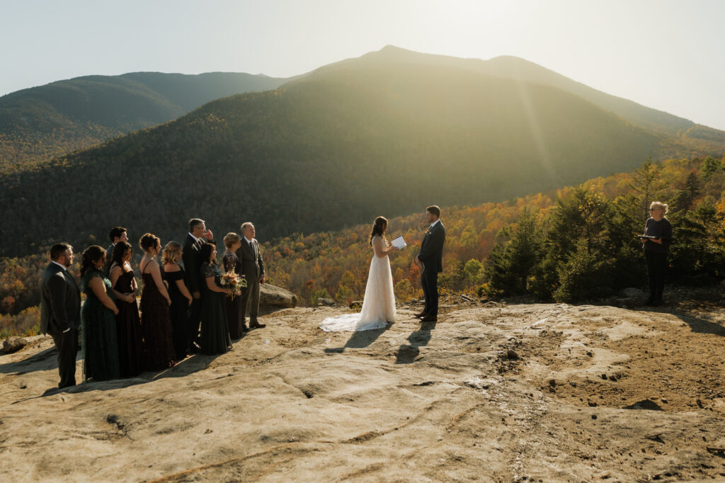 Couple legally gets married on top of a mountain in the adirondacks with family at sunset.