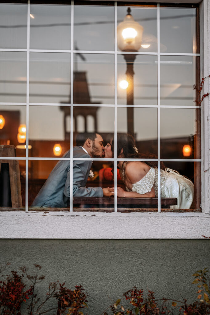 A couple who eloped in Lake george shares a kiss while drinking hot cocoa at a local coffee shop.