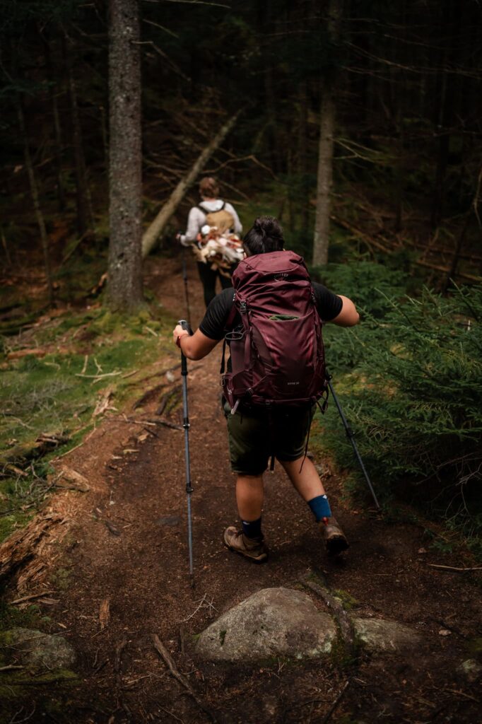 A couple hikes to their elopement location through the forest at Indian Head Mountain in the Adirondacks.