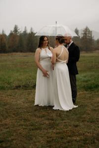Two brides reading their vows in a misty field in the Adirondack Mountains.