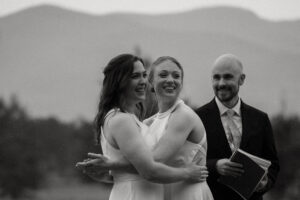 Two brides laughing and smiling after celebrating their first kiss as wife and wife.